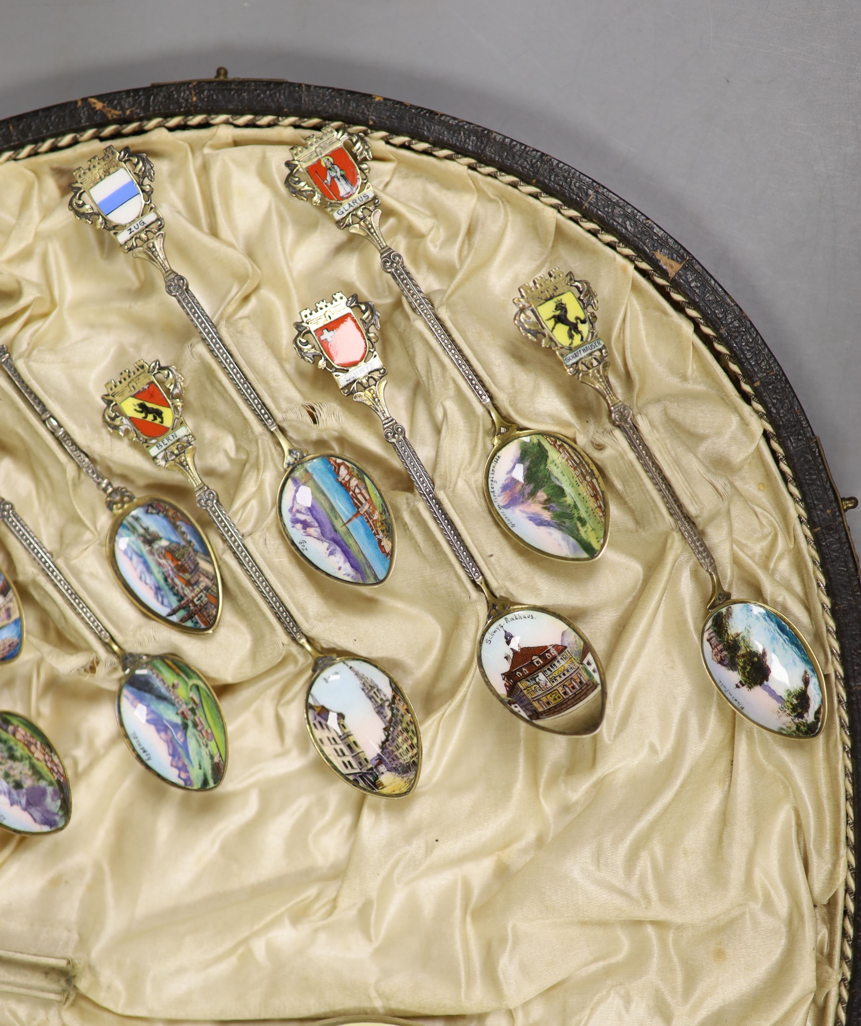 A set of 22 Swiss 800 silver and enamel souvenir spoons, each representative of a Canton, cased, with a larger spoon.